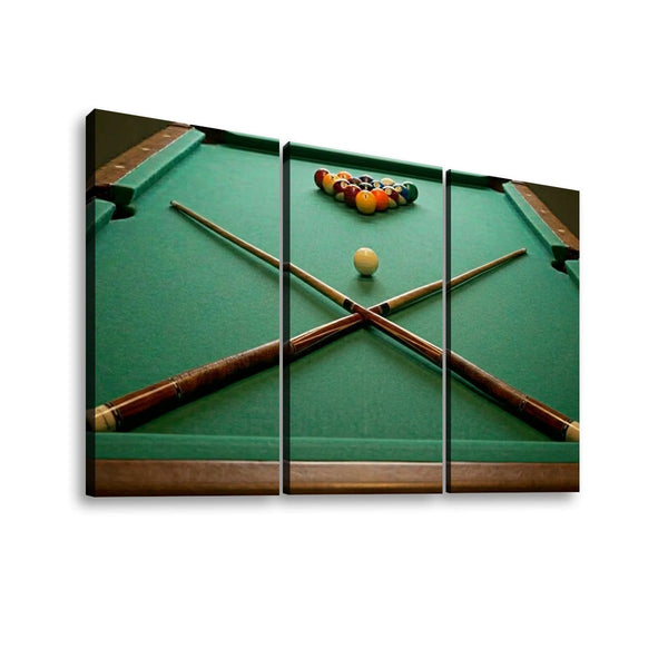 Three-panel canvas wall art showing a green pool table with crossed pool sticks, a single cue ball, and a rack of colorful billiard balls, displayed against a light gray background.