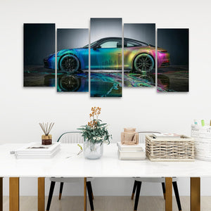 A five-panel canvas wall art set depicting a sports car with a vibrant rainbow iridescent finish, displayed on a white wall above a styled white table with books, a vase, and baskets.