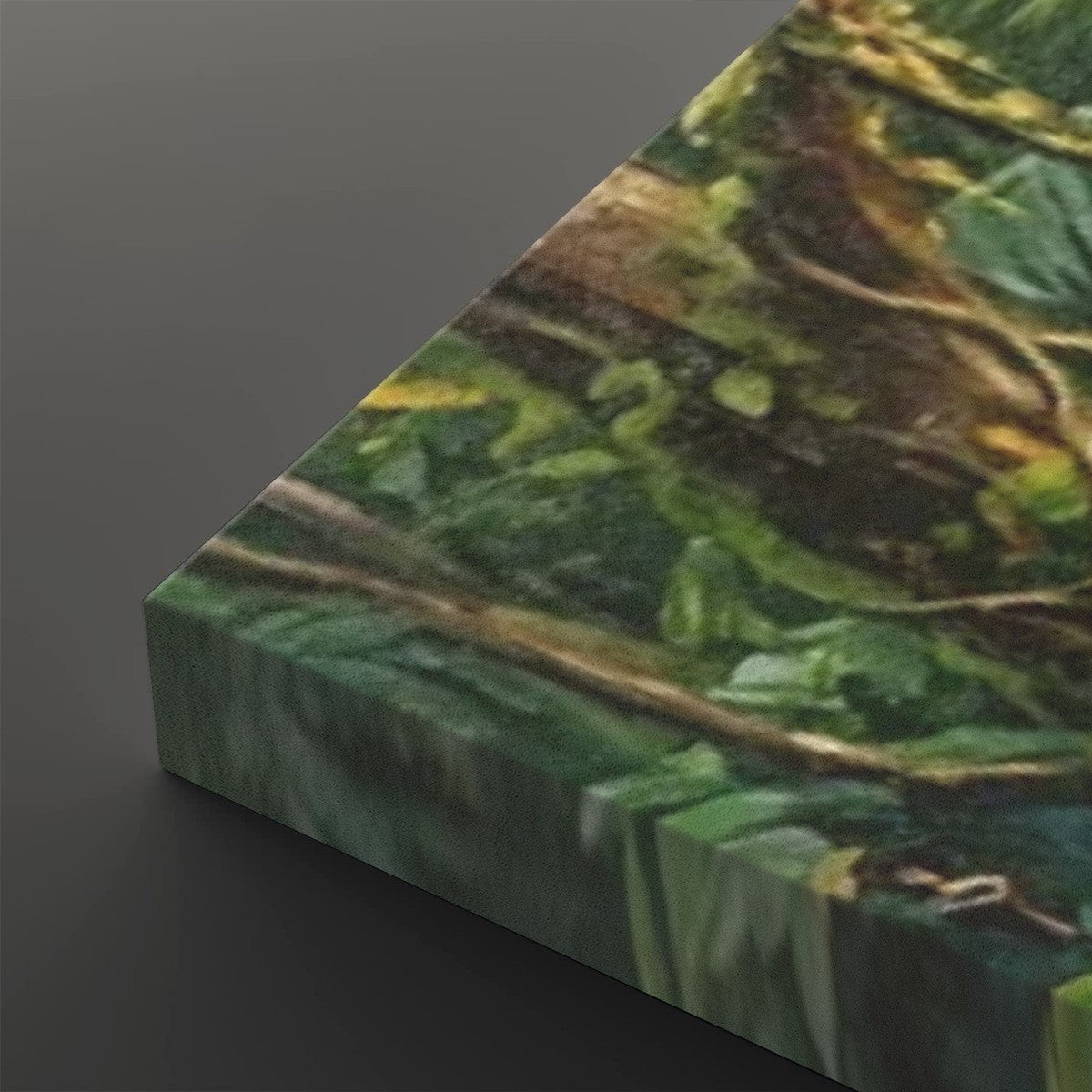 A close-up of a canvas or print showing a textured green and brown forest scene with leaves and branches, photographed at an angle against a dark gray background.