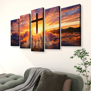 A five-panel canvas wall art set depicting a dramatic sunset sky with a large cross silhouette and clouds, displayed above a sofa in a living room setting.