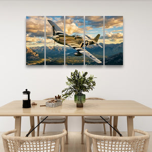 A five-panel canvas wall art set depicting a vintage military fighter plane flying over a mountain range under a dramatic cloudy sky, displayed on a white wall above a dining table with chairs and decorative items.