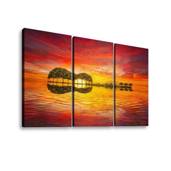 Three-panel canvas wall art showing a dramatic sunset over water with tree silhouettes and reflections, displayed against a light gray background.