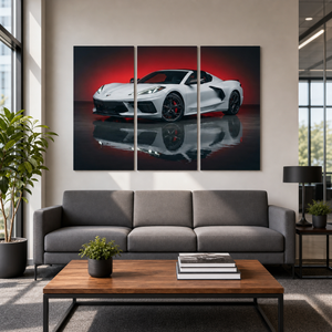 A three-panel canvas wall art print depicting a white sports car with a red reflection, displayed on a beige wall above a modern gray sofa in a styled living room.