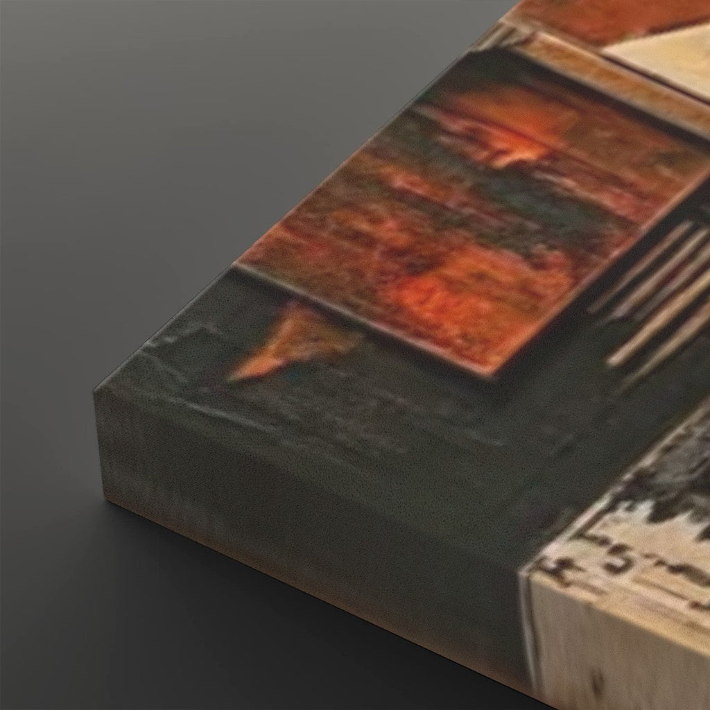 A close-up of a textured abstract canvas print showing a dark charcoal base with a prominent rust-orange geometric block and a light beige section, photographed on a dark gray background.