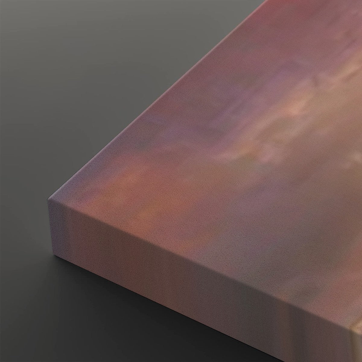 A close-up of a rectangular canvas or panel with a soft iridescent finish shifting between pink, purple, and peach tones, shown against a dark gray background.