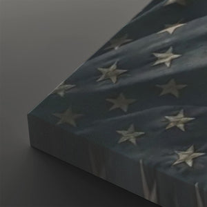 A close-up of a rectangular canvas or panel featuring a blue field with raised white stars, photographed at an angle against a dark gray background.
