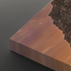 A close-up of a rectangular canvas or panel with a warm coppery-orange gradient surface and a dark textured edge, shown against a dark gray background.