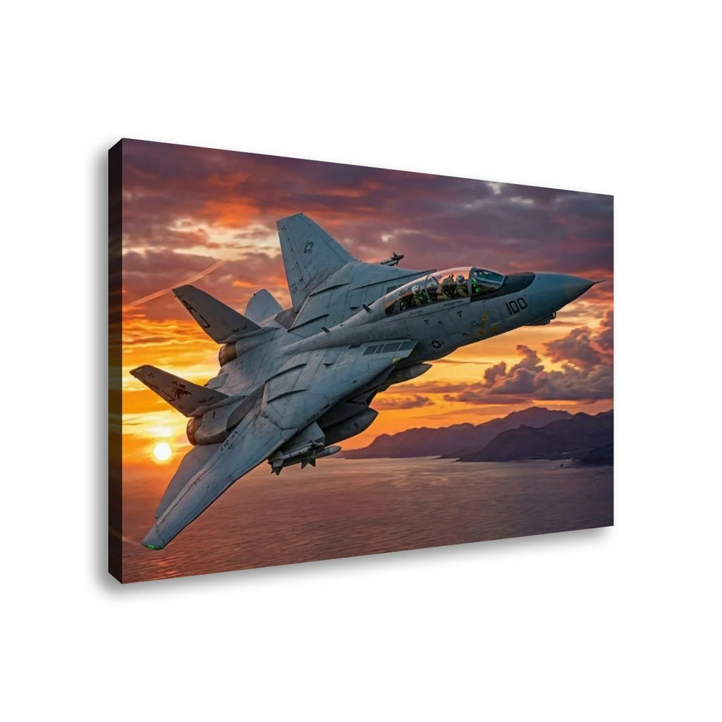 A rectangular wall art print or canvas showing a gray Grumman F-14 Tomcat  military fighter jet flying over water at sunset, with dramatic orange, pink, and purple clouds. The print is photographed at an angle against a plain white background.