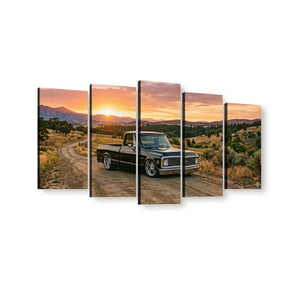 A five-panel canvas wall art set depicting a 1970 Chevy C10 Fleetside vintage pickup truck parked on a dirt road at sunset, with mountains and dry hills in the background, shown against a plain white wall.