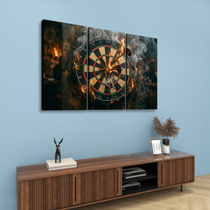 A three-panel canvas wall art set depicting a burning dartboard with smoke and flames, displayed on a light blue wall above a wooden console table with decorative items.