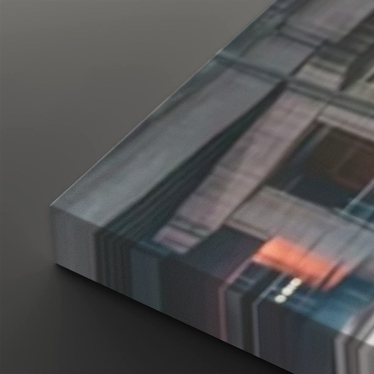 A close-up of a rectangular panel or block with a printed abstract geometric pattern in gray, blue, black, and a small orange accent, shown on a dark gray background.