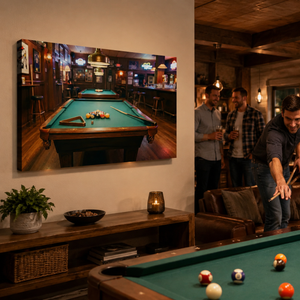 A large rectangular wall art print showing a pool hall scene with a green billiards table hangs on a beige wall in a real room. Several people are visible in the room, including one person leaning over a pool table in the foreground, so this is a Lifestyle image rather than a clean Product/Packaging shot.