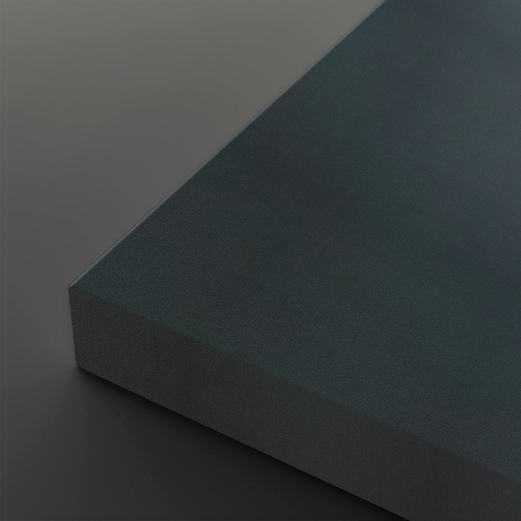A close-up studio shot of a rectangular block or panel corner, showing a matte dark teal-blue textured surface on top and a lighter gray side edge, set against a matching dark gray background.
