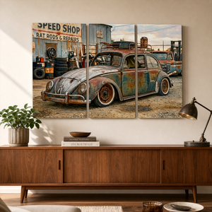 A three-panel canvas wall art print depicting a rusty vintage Volkswagen Beetle in a speed shop, displayed on a beige wall above a wooden sideboard in a modern living room setting.