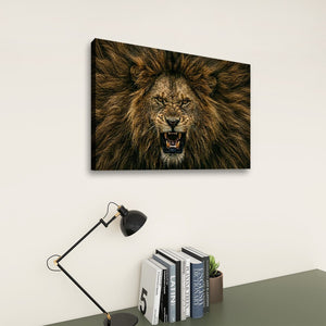 A rectangular wall art print showing a close-up lion face with an open mouth, displayed above a desk with books and a lamp in a styled interior setting.