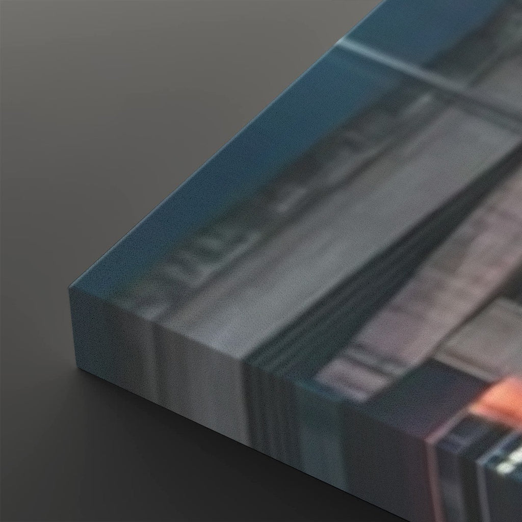A close-up of a rectangular canvas or print showing an abstract blurred scene in blue, gray, white, and black tones, photographed on a dark gray background.