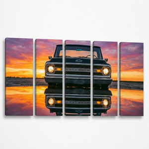 A five-panel canvas wall art set depicting a vintage 1970 Chevy C10 facing forward on a reflective wet road at sunset, with vivid orange, pink, and purple sky tones.