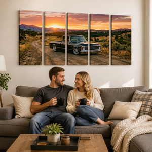 A five-panel canvas wall art set depicting a black vintage 1970 Chevy C10 Fleetside pickup truck on a dirt road at sunset, displayed on a beige wall above a couple sitting on a gray sofa in a cozy living room.