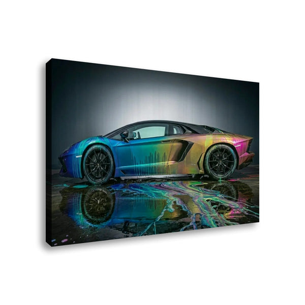 A rectangular wall art print or canvas showing a side view of a Lamborghini Aventador sports car with a vivid iridescent rainbow finish, reflected on a wet dark surface. The artwork is photographed against a plain white background.