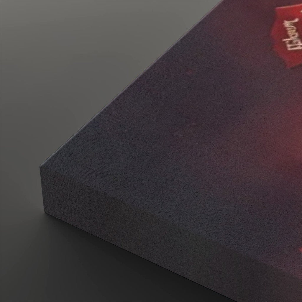 A close-up of a dark rectangular product, likely a book or box, showing a textured dark gray-blue front and a red corner label with white text, photographed on a dark gray background.