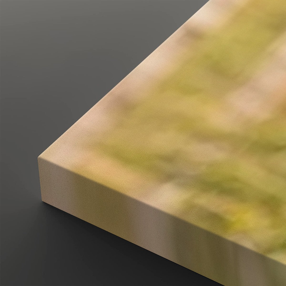 A close-up of a rectangular block or panel corner with a blurred yellow-green and beige surface, photographed against a dark gray background.