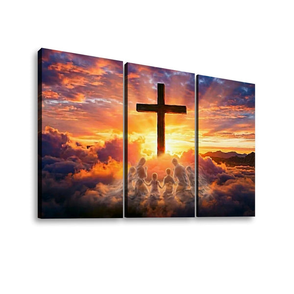 Three-panel canvas wall art showing a dramatic sunset sky with clouds, a large cross silhouette, and small human figures against the light, displayed on a white background.