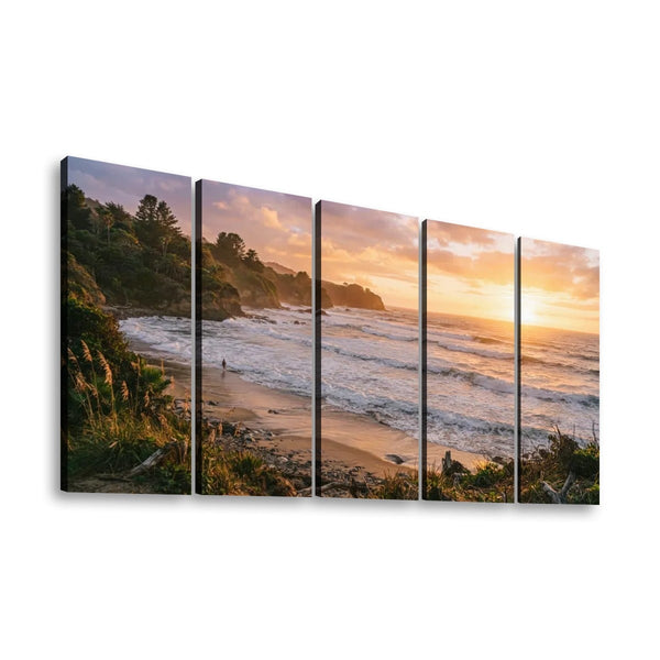 A five-panel split canvas wall art print depicting a coastal beach at sunset, with waves, cliffs, trees, and golden sky, shown against a plain white background.
