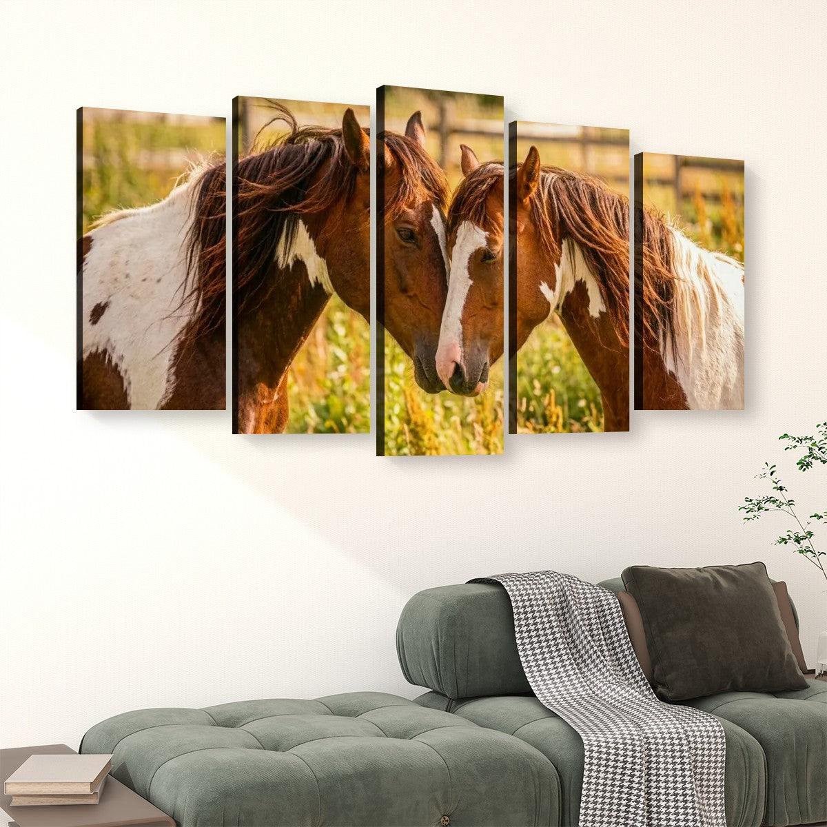 A five-panel canvas wall art set depicting two brown and white horses facing each other in a sunlit field, displayed above a green sofa in a living room setting.