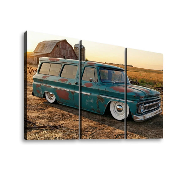 A three-panel canvas wall art print depicting a vintage teal 1966 Chevy Suburban Carryall parked outdoors on dirt near a barn and field at sunset.