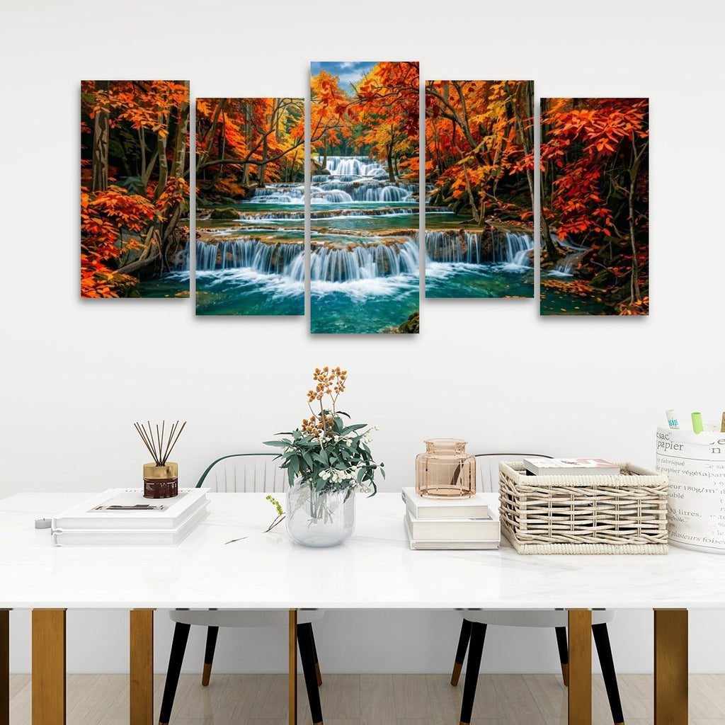 A five-panel canvas wall art set depicting a colorful Huay Mae Khamin Fallsl, displayed on a white wall above a styled dining table with books, a vase, and a basket.