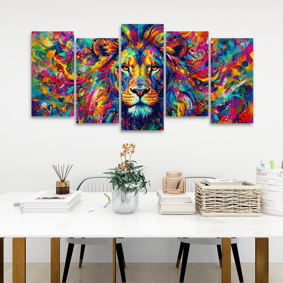 A five-panel canvas wall art set depicting a colorful, abstract lion head, displayed on a white wall above a styled dining table with books, a vase, and a basket.