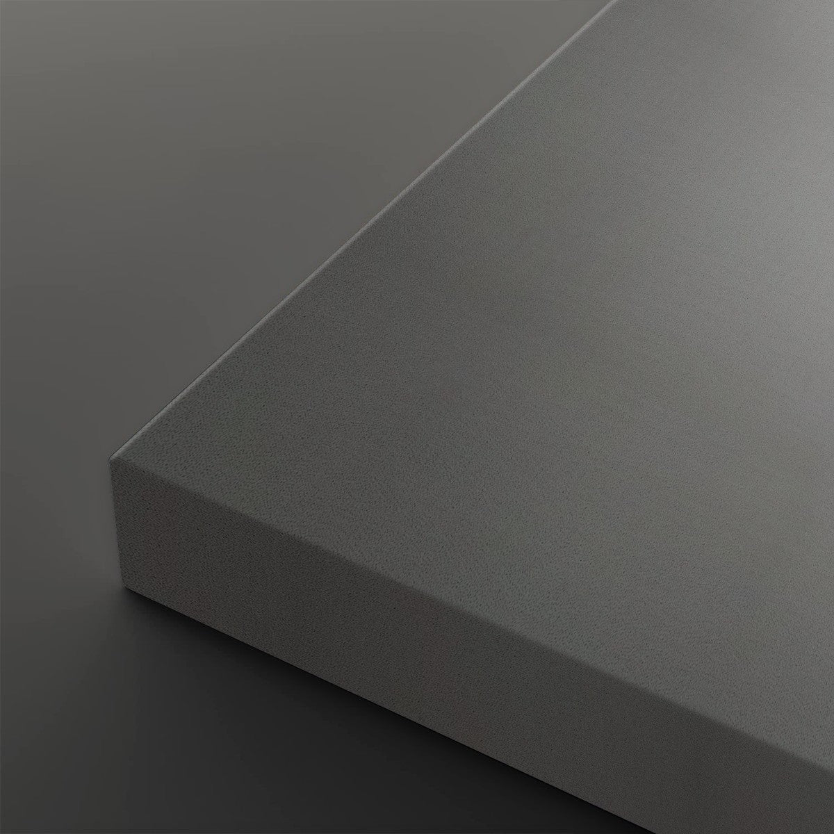 A close-up studio shot of a matte gray rectangular panel or block corner, shown against a matching dark gray background.