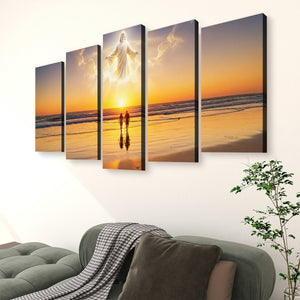 A five-panel canvas wall art set depicting a glowing figure on a beach sunset, displayed above a green sofa in a living room setting.