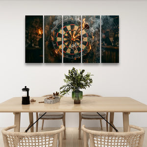 A five-panel canvas wall art set depicting a burning dartboard in a dimly lit bar, displayed on a white wall above a wooden dining table with chairs.