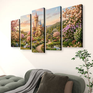 A five-panel canvas wall art set depicting a whimsical fairytale castle surrounded by blooming cherry blossom trees, purple flowers, and a winding path at sunset, displayed on a white wall above a green sofa with a throw blanket and a potted plant.