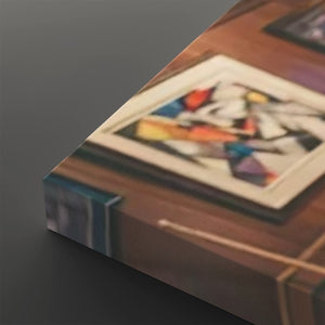 A close-up angled view of a framed abstract art print resting on a wooden surface, with the frame and colorful artwork visible against a dark gray background.