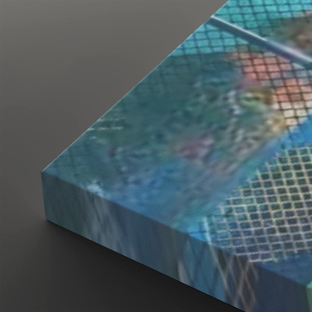 A close-up of a rectangular canvas or print showing an abstract blue and teal grid-like scene with blurred warm tones, photographed against a dark gray background.