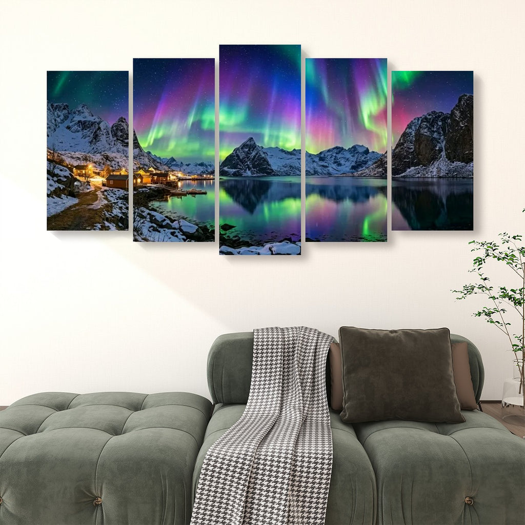 A five-panel canvas wall art set depicting a snowy mountain landscape with glowing aurora lights reflected in calm water, displayed above a green sofa in a modern living room setting.