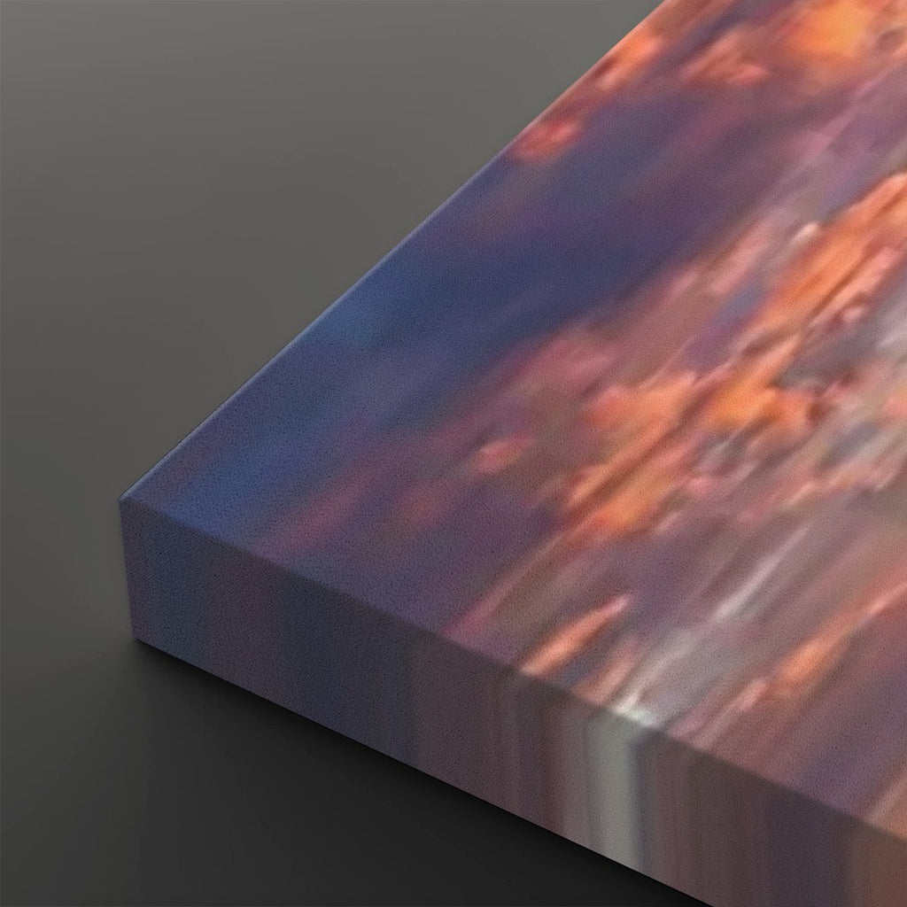 A close-up of a rectangular canvas or print showing an abstract landscape-like scene with flowing bands of blue, purple, orange, and pink, photographed on a dark gray background.