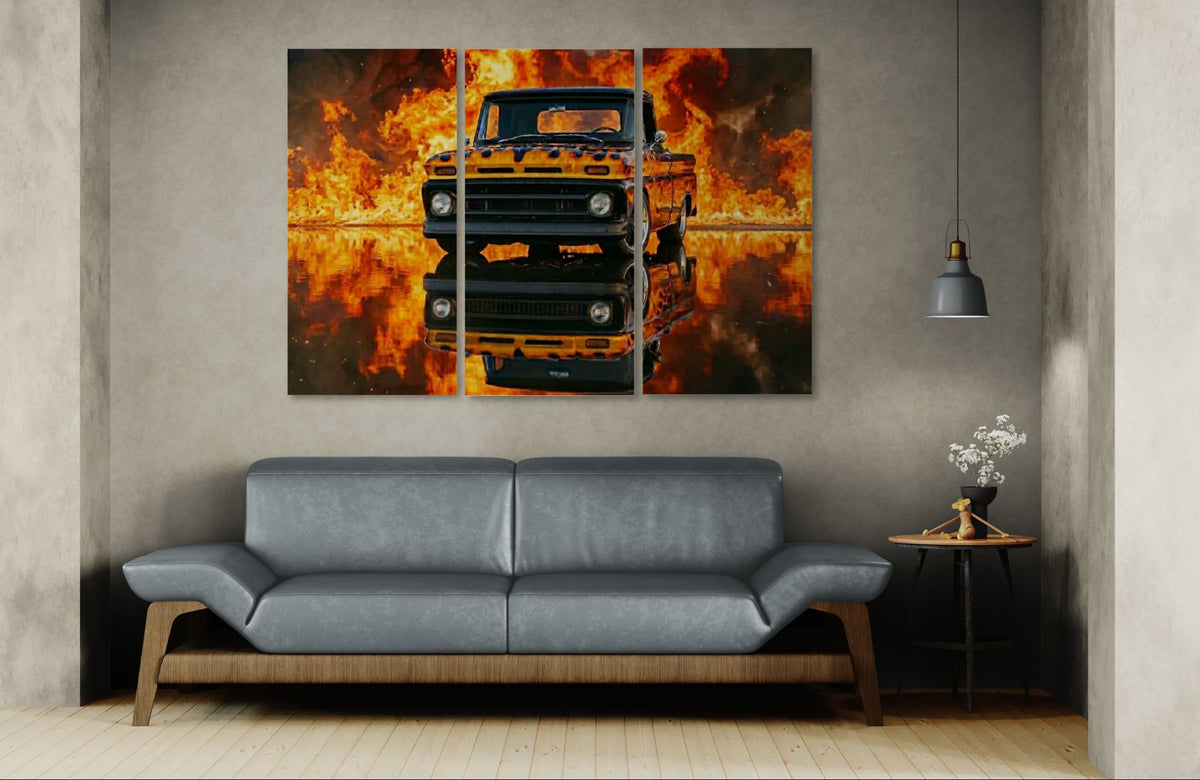 Two framed artworks of a truck on fire above a gray sofa in a room.