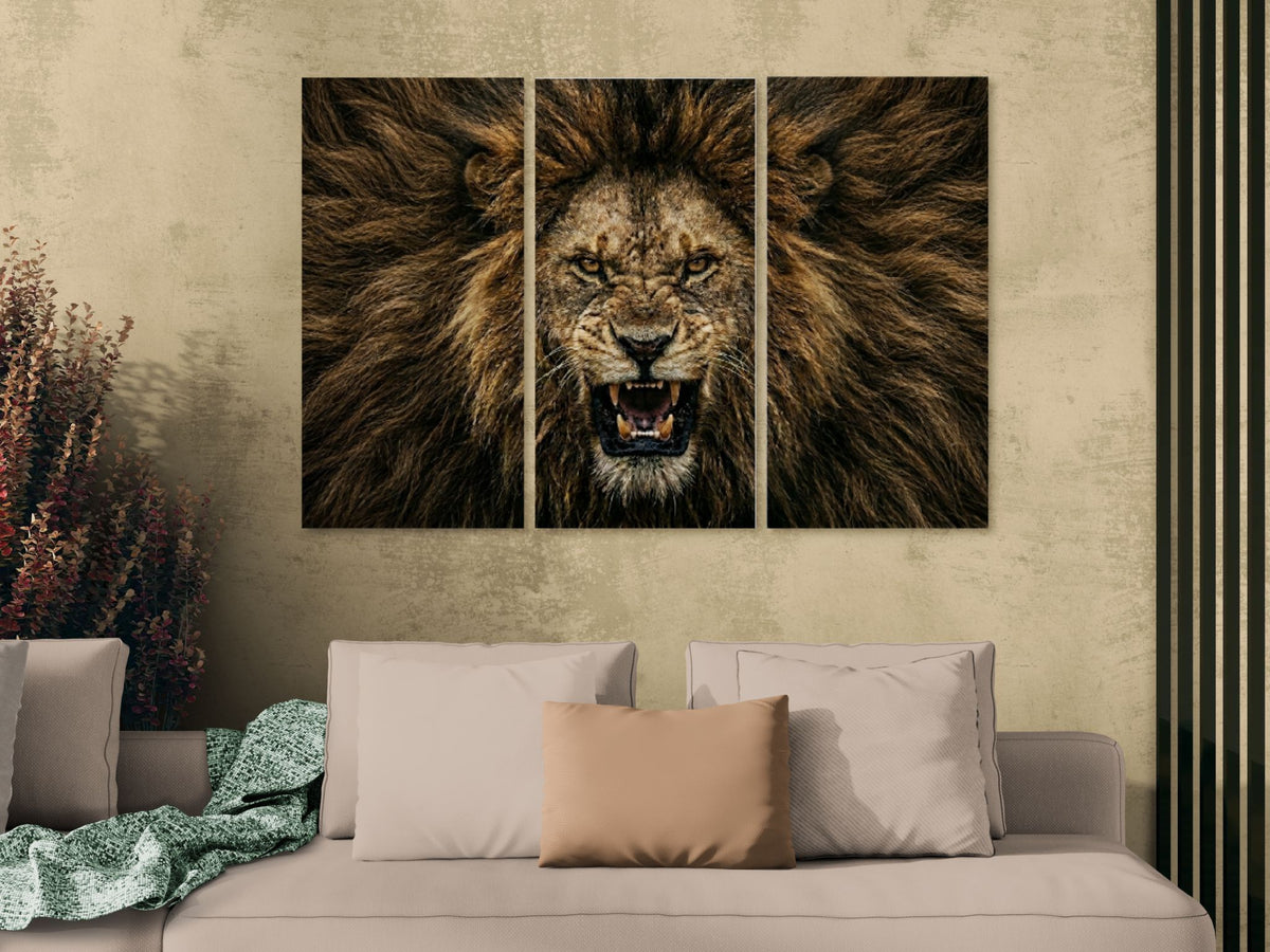 Triptych wall art of a roaring lion above a sofa with decorative pillows.
