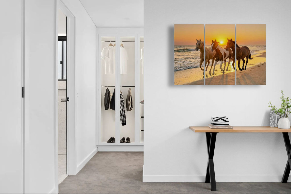 Modern interior with a wall art of horses on a beach at sunset.