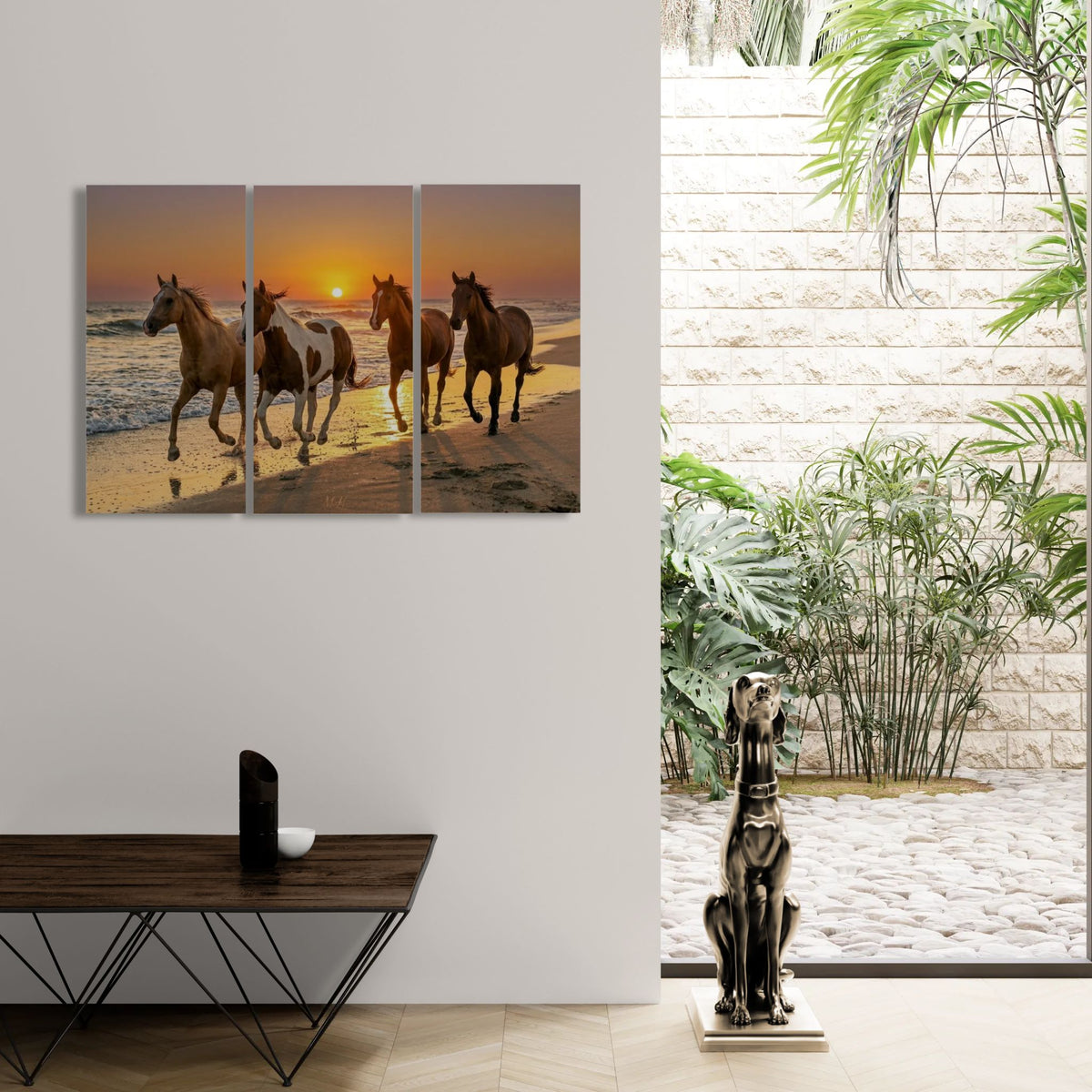 Three-panel artwork of horses on a beach at sunset, displayed in a modern interior setting with a statue and table.