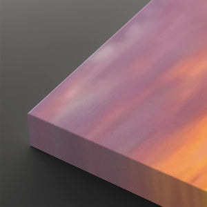 A close-up of a rectangular canvas or panel with a soft gradient surface shifting from lavender and pink to peach and orange, shown against a dark gray background.