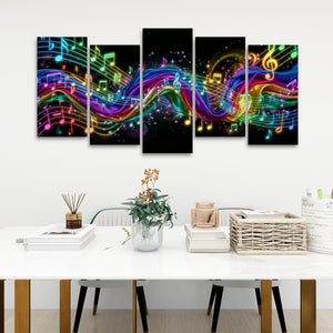 A 5-panel canvas wall art set depicting vibrant, flowing musical notes and treble clefs in neon rainbow colors on a black background, displayed in a modern living room setting above a white table.