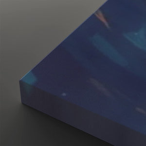 A close-up of a rectangular canvas or panel with a dark blue abstract print, showing its thickness and corner against a neutral gray background.