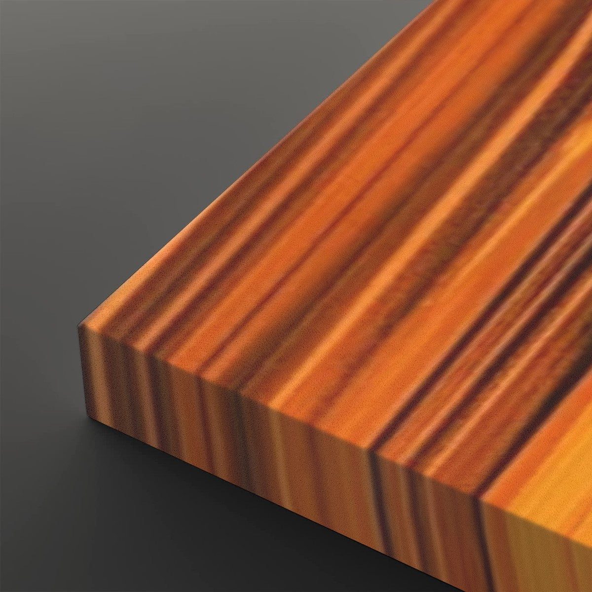 A close-up of a rectangular wooden board or block with a rich striped wood grain pattern in warm orange, brown, and golden tones, shown against a dark gray background.