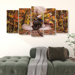 A five-panel canvas wall art set depicting a black steam locomotive traveling through an autumn forest with colorful fall foliage, displayed above a green sofa in a living room setting.