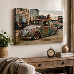 A rectangular wall art print showing a vintage rusted Volkswagen Beetle in front of a speed-shop sign, displayed above a wooden console table in a styled interior with a plant, clock, books, and vase.