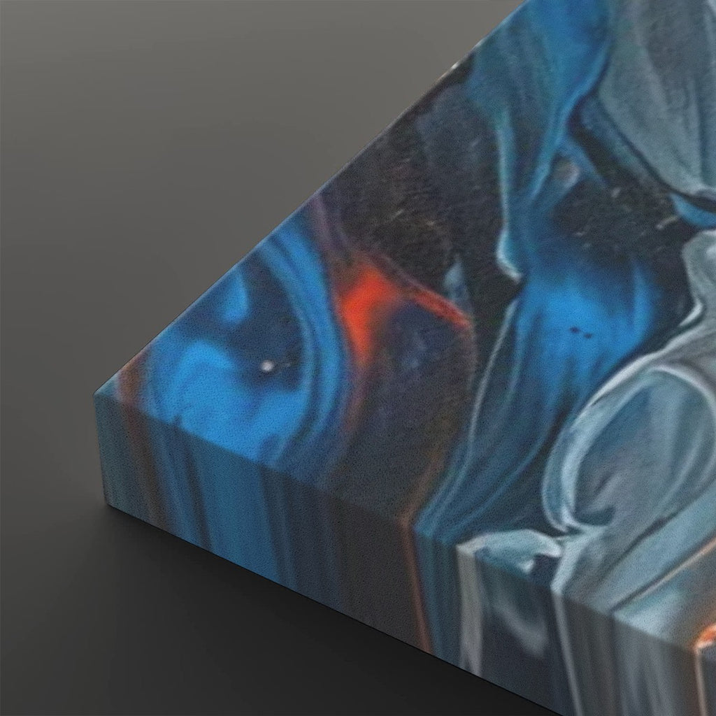 A close-up of a square canvas print showing an abstract fluid art design with swirling patterns of blue, black, white, and a small orange accent, photographed on a dark gray background.